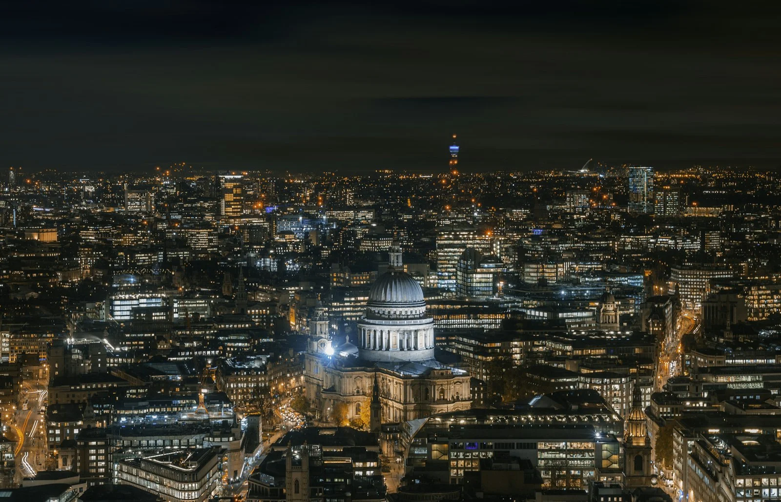 Illuminated offices surrounding St Paul's Cathedral in London at night, where many UK accountants work
